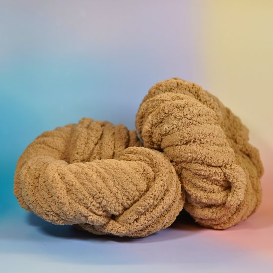 Deux pelotes de fil chenille marron clair, pelucheuses, avec des mèches épaisses et torsadées.