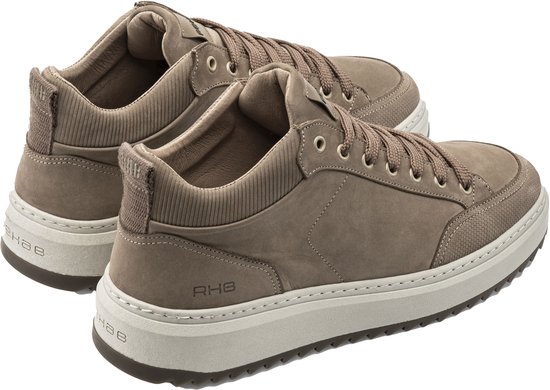 Twee beige suède sneakers met vetersluiting en RHEB-logo op de zijkant.
