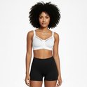 Vrouw met krullend haar, draagt een witte sportbeha met rits aan de voorkant en zwarte short.