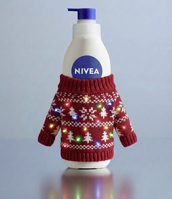 NIVEA bodylotion fles in een rood gebreide kersttrui met lichtjes.