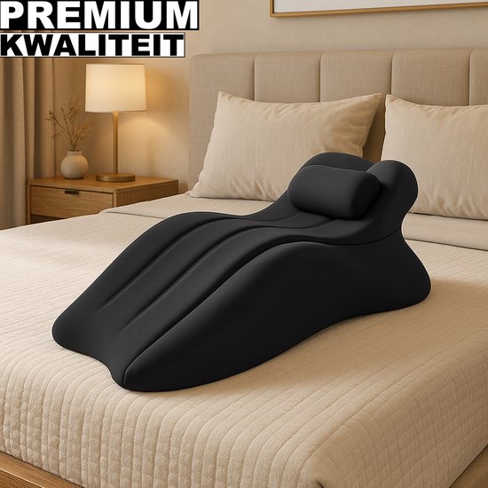 Zwarte opblaasbare positiekussen met nekkussen op een bed.