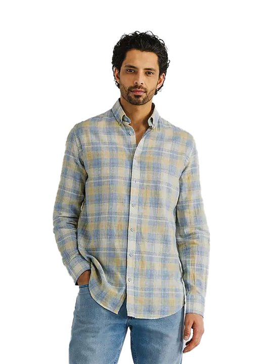 Man met een geel-blauwe geruite, lange mouwen overhemd van State of Art, met jeans.