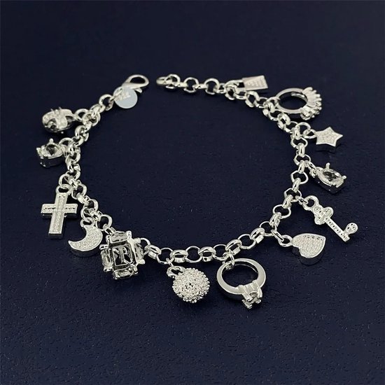 Zilverkleurige schakelarmband met diverse bedels: kruis, maan, kristallen bol, bal, ring, hart, ster, sleutel en een slotje.