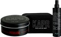 Zwart blikje KAPR Pomade, een zwarte toilettas en een zwarte fles KAPR Tonic op een witte achtergrond.