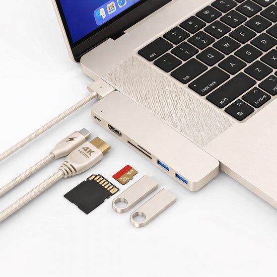 Een laptop, een lichtgrijze USB-C hub, met 4K HDMI-kabel, USB-sticks en geheugenkaarten ernaast.