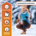 Vrouw met blauwe sportkleding in de sneeuw, knielend. Luchtgeactiveerd, verwarming in minuten, duurt 6 uur, gem. temp 158°F / 70°C.