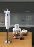 Witte Braun staafmixer met blauwe knop, naast een hakmolen met chocolade en een schaaltje dessert.