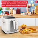 Witte Tefal frituurpan met een bord met friet, kipnuggets en ringen.