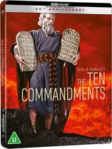 Hoes van The Ten Commandments: Moses, een oude man met een grijze baard, draagt een paars gewaad en houdt twee stenen tabletten omhoog.