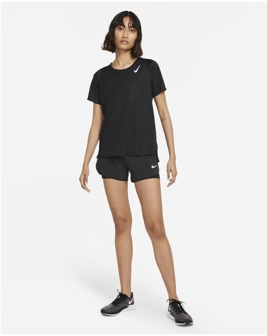 Model in volledig zwarte Nike outfit: sportshirt met korte mouwen en shorts.