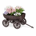Bruin metalen wagentje gevuld met diverse bloemen, staand op kiezelstenen.