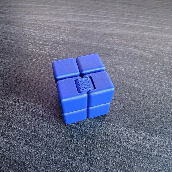 Blauwe fidget cube met een klikmechanisme in het midden.