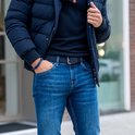 Homme portant une veste bleu marine, un pull bleu marine et un jean bleu. Ceinture en daim bleu marine avec boucle argentée.