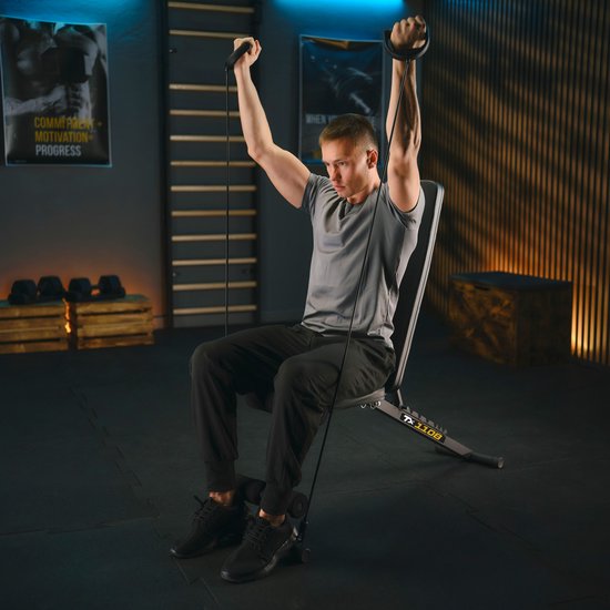Man in grijs shirt traint met een zwarte fitnessbank en weerstandsbanden.