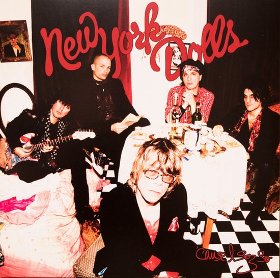 New York Dolls Cause I Sez So albumhoes met vijf bandleden, waarvan één gitaar speelt, en een tafel met flessen en eten.