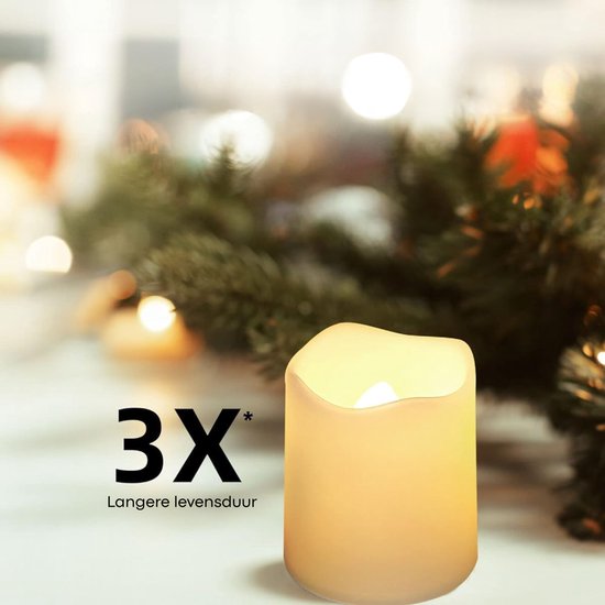 Een enkele witte LED-kaars met een warme, flakkerende vlam, met de tekst '3X * Langere levensduur' op de voorgrond tegen een decor van kerstgroen.