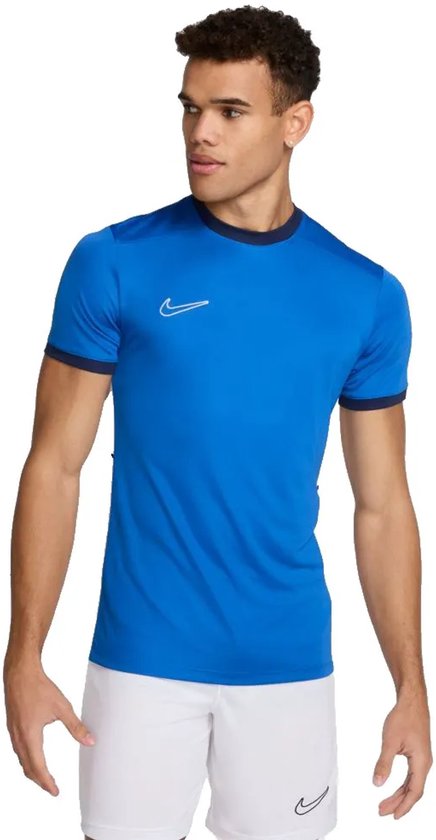 Man in een blauw Nike sportshirt met witte broek.