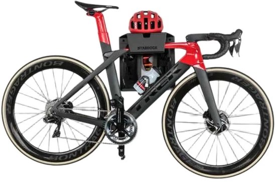 Zwarte en rode racefiets met helm en bidon op een Stasdock muurbeugel.