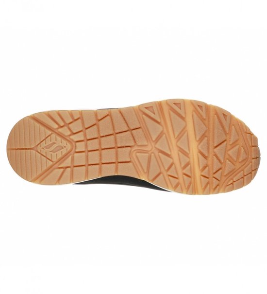 Zool van een zwarte sneaker met bruine, gripvaste rubberen onderkant.