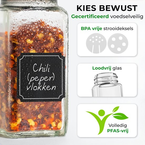 Glazen kruidenpotje gevuld met chilivlokken. Zwart etiket met handgeschreven tekst "Chili (peper) vlokken".