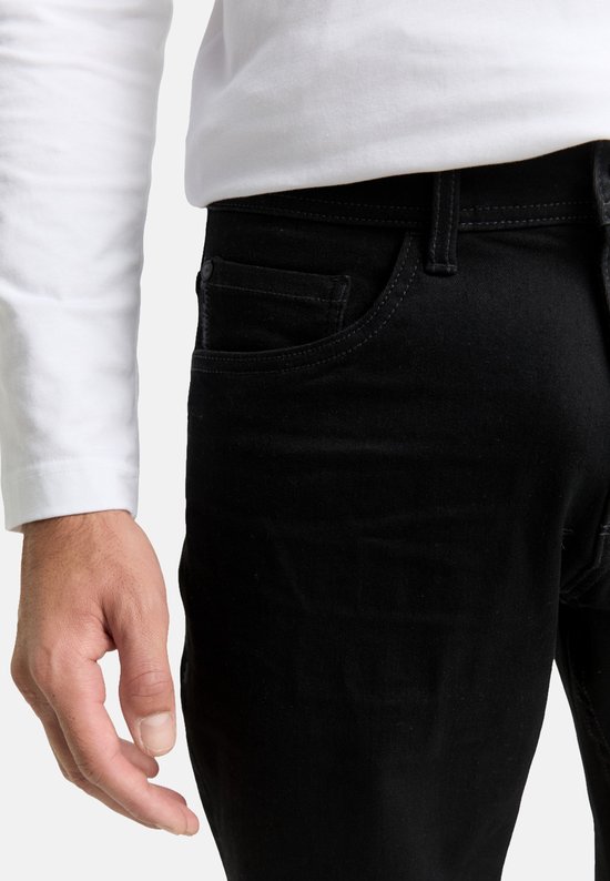 Detail van de zakken van een zwarte jeans, gedragen door een man.