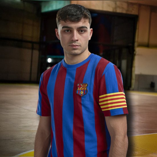 Man draagt een retro FC Barcelona shirt met blauwe en rode verticale strepen en een embleem.