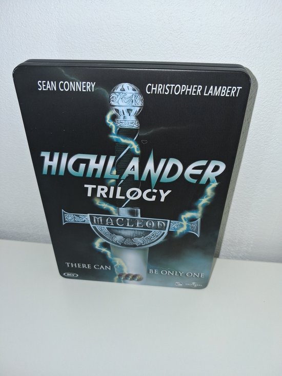 Voorkant van de Highlander Trilogy metalen box met zwaard, bliksem en de tekst "There Can Be Only One".