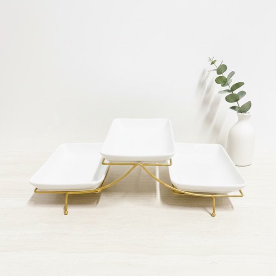 Drielaags witte serveerschaal met gouden metalen frame. Drie rechthoekige schalen op verschillende hoogtes.