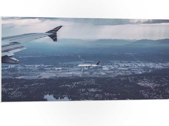 WallClassics - PVC Schuimplaat - Twee Vliegtuigen vlak boven het Land - 100x50 cm Foto op PVC Schuimplaat (Met Ophangsysteem)