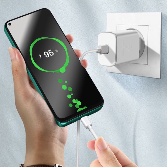 Hand laadt een groene telefoon op met 95% batterij met een witte snellader.