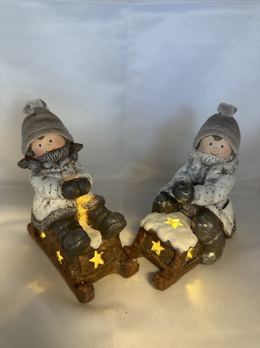 Kerstbeeldjes jongen en meisje op slee met LED - Wit+grijs & grijze stoffen mutsjes - 15 cm hoog x 11 cm x 5cm – Kerstdecoratie