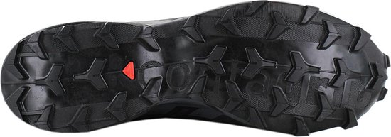 Zool van een zwarte Salomon trailrunningschoen met grof, hoekig profiel en een rood driehoekig detail.