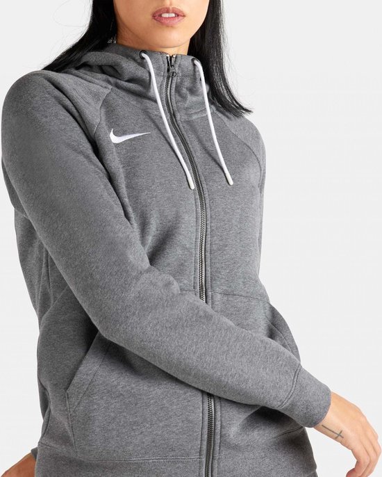 Close-up van een grijs Nike fleece trainingsvest met witte trekkoorden en Nike logo op de borst.