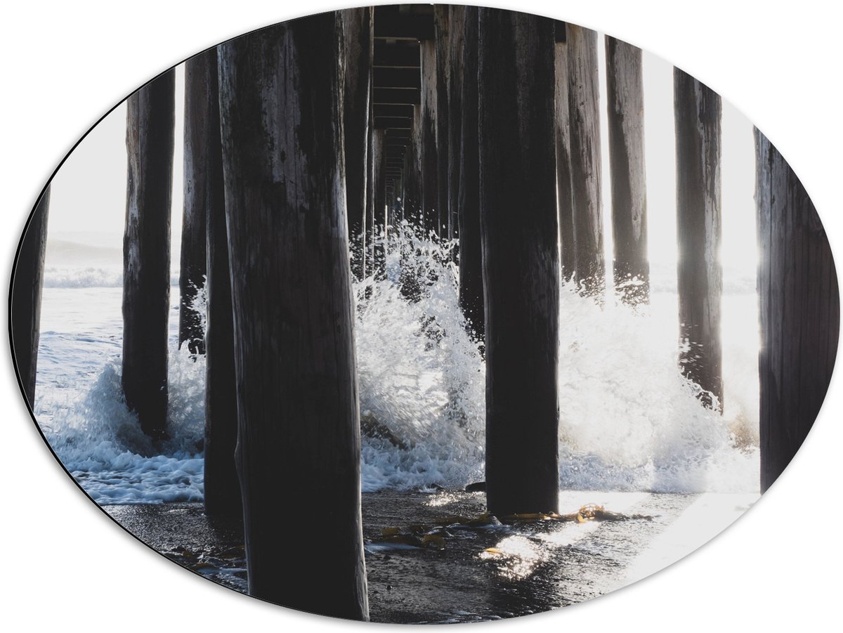 Dibond Ovaal - Water klots4end tegen Houten Palen in de Zee - 68x51 cm Foto op Ovaal (Met 