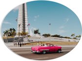 WallClassics - PVC Schuimplaat Ovaal - Roze Auto bij Gebouw in Cuba - 80x60 cm Foto op Ovaal (Met Ophangsysteem)