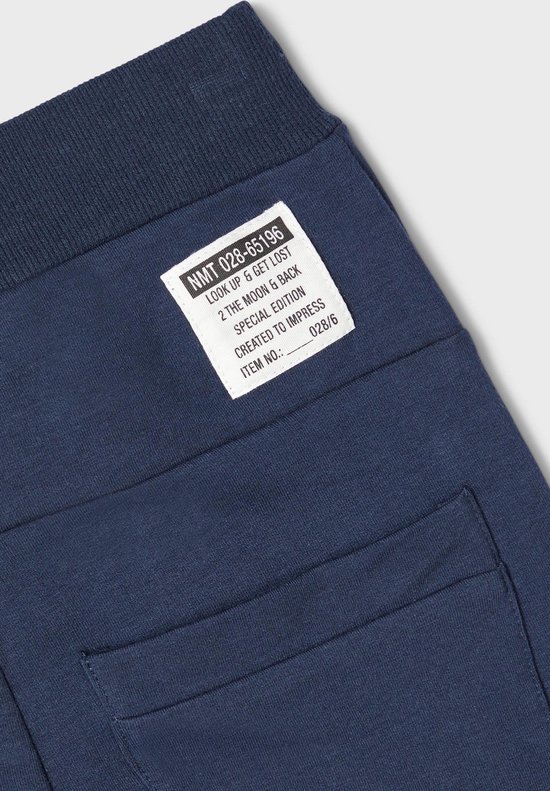 Label op donkerblauwe joggingbroek met tekst: NMT 028-65196 LOOK UP & GET LOST SPECIAL EDITION CREATED TO IMPRESS.