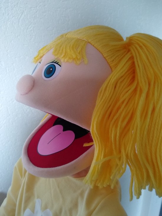 Handpop met geel haar, blauwe ogen en open mond met rode tong.