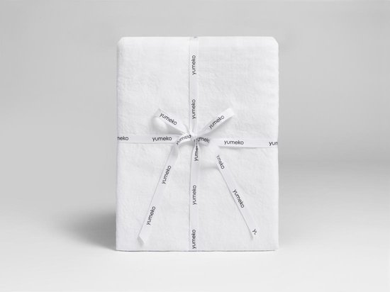 Wit linnen product, verpakt met een lint met 'yumeko' logo.