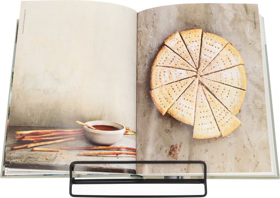 Open kookboek met op de rechterpagina een ronde koek, in punten gesneden en bestrooid met poedersuiker. Op de linkerpagina een schaal met rode dip en lange, dunne koekjes.