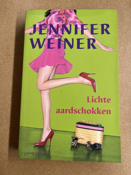 Boek 'Lichte aardschokken' met een vrouw op een knalgroene achtergrond, gekleed in een roze jurk en rode pumps.