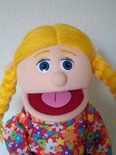 Buiksprekpop Cindy met blonde vlechten, blauwe ogen en een vrolijke bloemenblouse.