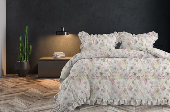 Een opgemaakt tweepersoons bed met dekbedovertrek, versierd met ruches en een delicate bloemenprint.