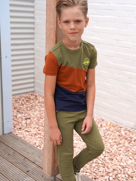 Jongen met korte broek met een groen, bruin en blauw colorblock t-shirt met opdruk.