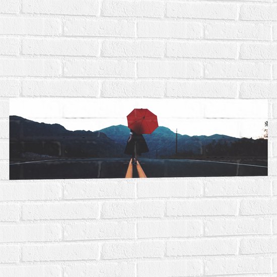 WallClassics - Muursticker - Vrouw met Rode Paraplu op de Weg - 90x30 cm Foto op Muursticker