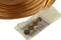Gouden Boeddha hoofd met een plastic zakje met vier munten.