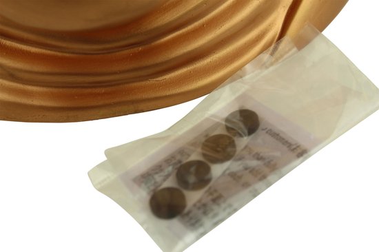 Gouden Boeddha hoofd met een plastic zakje met vier munten.