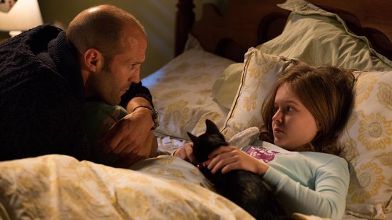 Een man met een gebreide trui kijkt naar een meisje in bed, met een zwarte kat.
