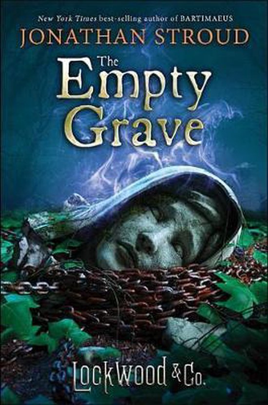 Boekcover van "The Empty Grave" door Jonathan Stroud. Een slapende steenhoofd ligt half begraven, omringd door kettingen en bladeren.