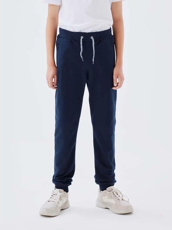 Jongen in donkerblauwe joggingbroek met trekkoord.