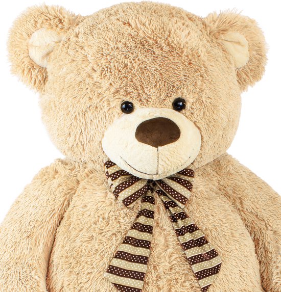 Grote beige teddybeer met bruine stippen en strepen strik. Donkere ogen en neus.